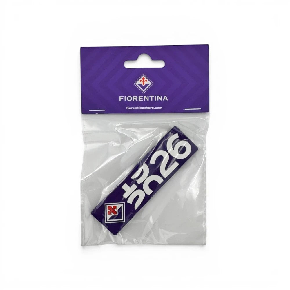 Am Ball ACF Fiorentina 100-Jahre-Jubiläums-Magnet in Lila mit Vereinslogo und weißem Schriftzug in Plastikverpackung