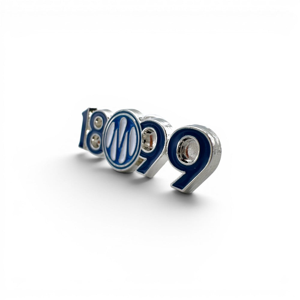 Am Ball Anstecker mit der Jahreszahl 1899 und dem Logo des Vereins in Blau und Weiß.