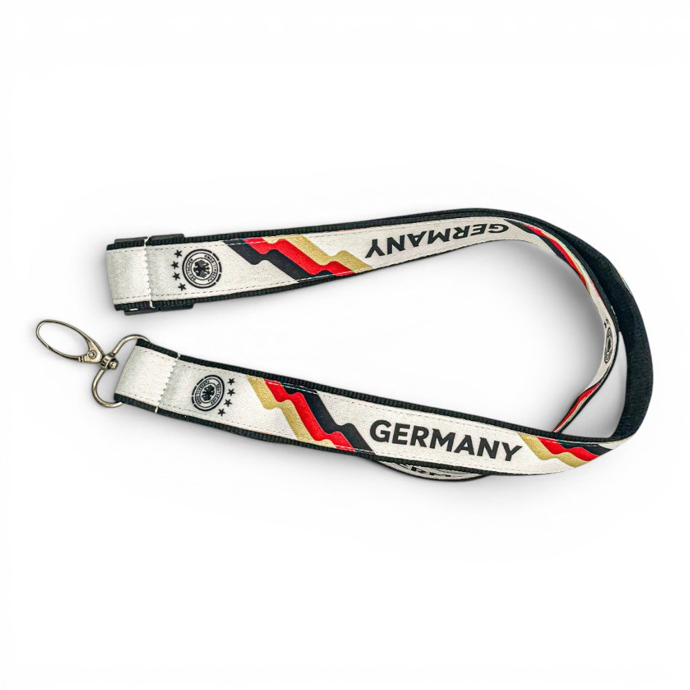 Am Ball DFB Lanyard in Weiß mit schwarz-rot-goldenen Streifen, DFB-Logo und Germany-Schriftzug mit Metallkarabiner.