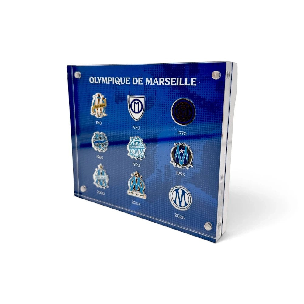 Am Ball Acrylrahmen mit historischen Olympique de Marseille Vereinslogos auf blauem Hintergrund