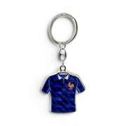 FFF Schlüsselanhänger in Form eines blauen Trikots mit "Equipe de France"-Schriftzug und Einkaufswagen-Jetons. Aus Zamak.