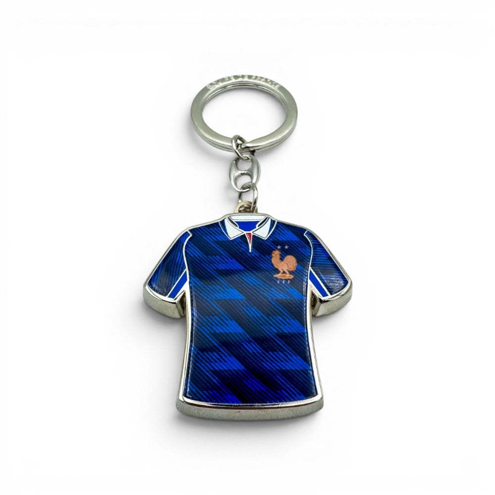 Schlüsselanhänger in Form eines blauen Frankreich-Trikots mit Hahn-Logo und Einkaufswagen-Jetons. Zamak.