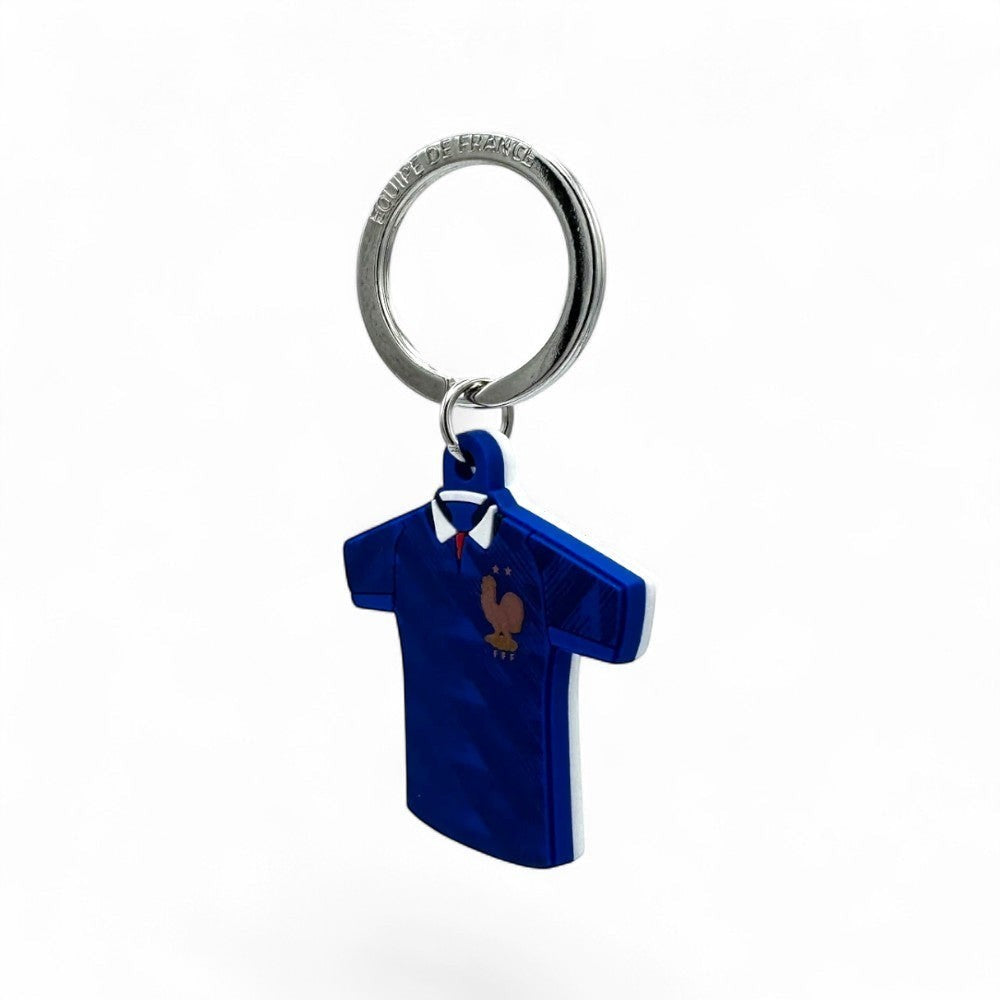 Frankreich WM 2026 Schlüsselanhänger in Trikotform, blau mit weißem Kragen und rotem Akzent, PVC.