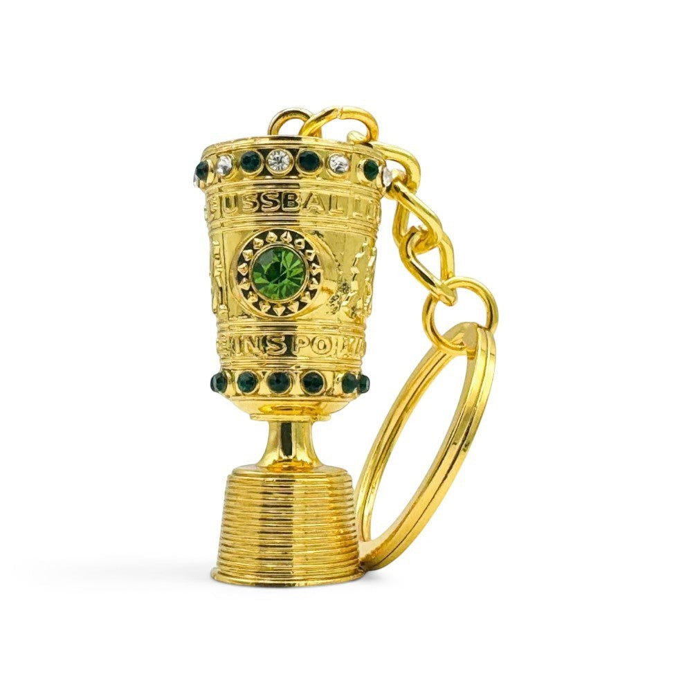 Close-up of the DFB Pokal mini trophy keyring showing the intricate engraving and golden finish.