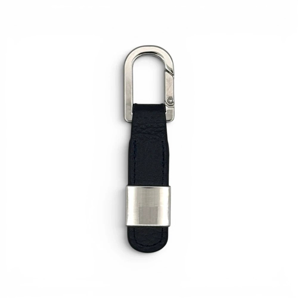 The Open Leder-Schlüsselanhänger in Schwarz mit silberfarbenem Metallkarabiner und dekorativer Metallspange