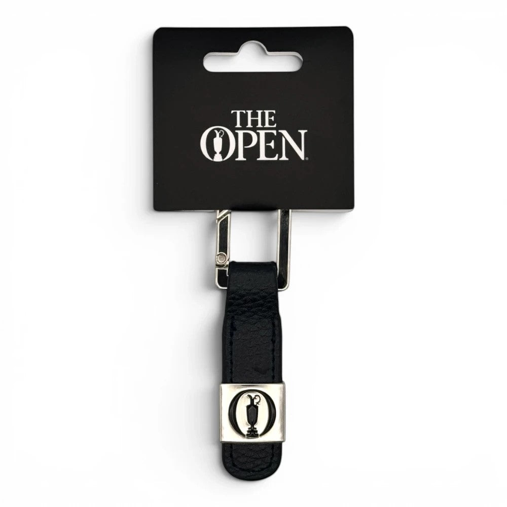 The Open Leder-Schlüsselanhänger in Schwarz mit silbernem Trophäen-Emblem auf der Verpackung