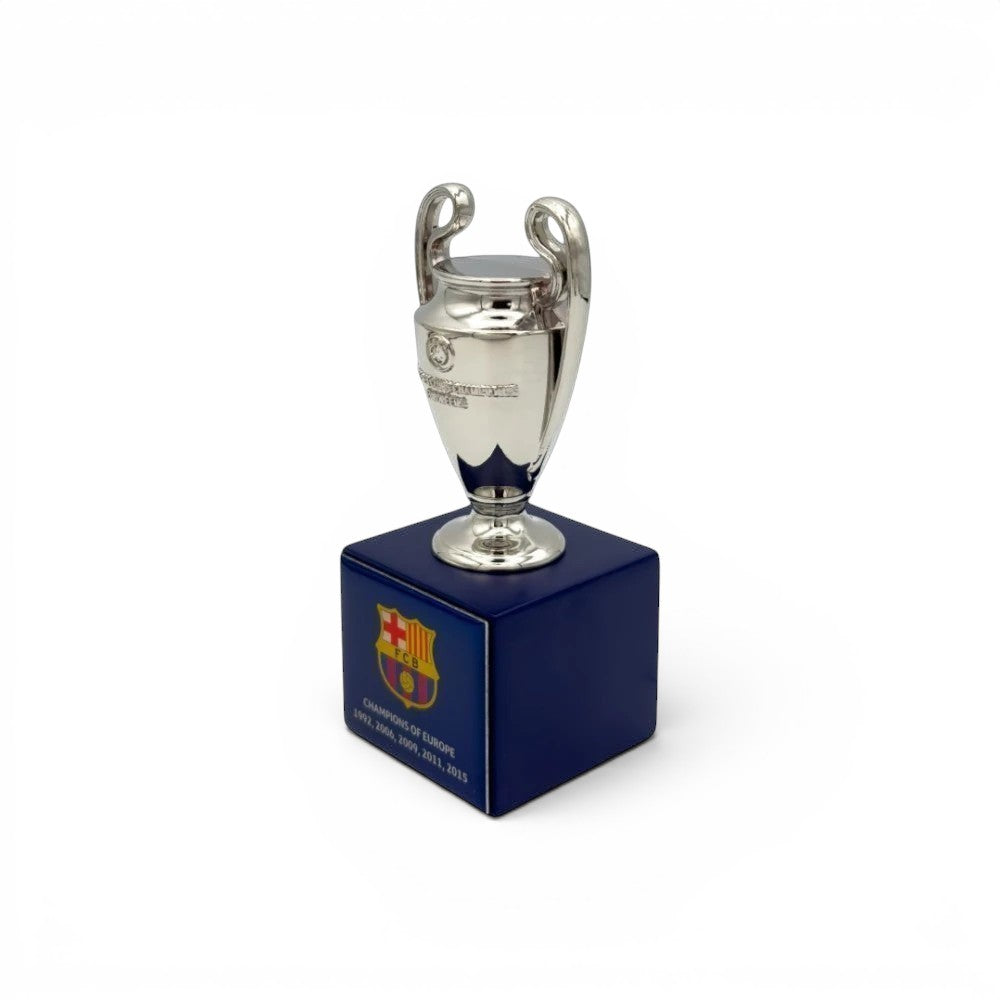 UEFA Champions League Pokal-Replika (70mm) aus Zamak auf blauem Holzsockel mit FC Barcelona-Logo und Titeln.